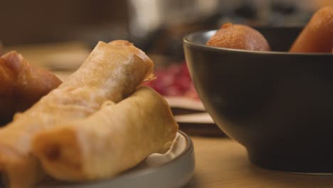 primer plano de rollitos de primavera y gulab jamun en la mesa de la familia musulmana en casa para comer celebrando el eid