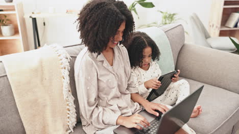 laptop, tablet and mother with child on sofa