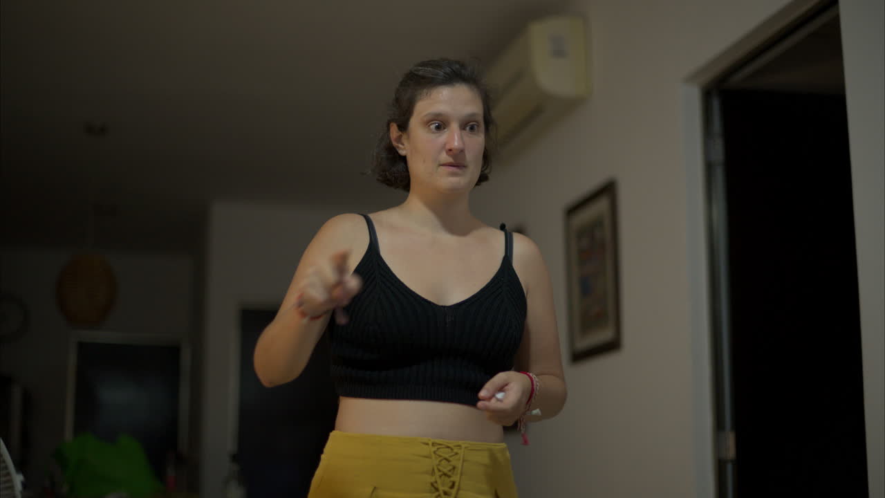 Rallentatore di una donna bruna che gioca a un gioco di mimica scrivendo una lettera "z" nell'aria.