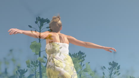 animation of meadow over caucasian woman with arms outstretched