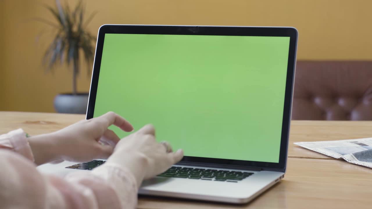 mujer trabajando en una computadora portátil con una pantalla verde