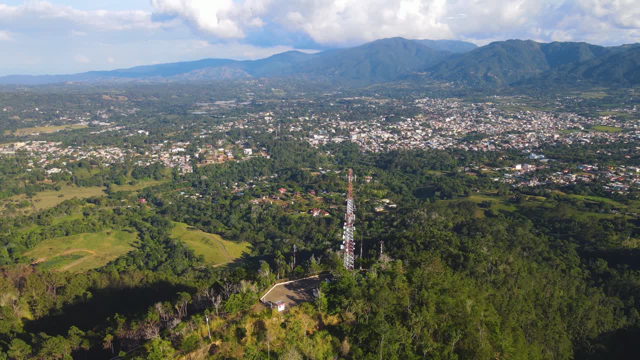 torre de comunicación móvil en las montañas, vista aérea con la ciudad al fondo y rodeada de naturaleza