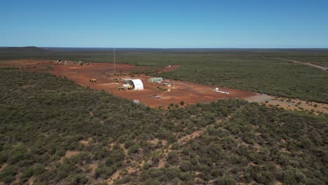 Toma-Aérea-Acercándose-A-Una-Pequeña-Mina-En-El-Oeste-De-Australia-Rodeada-De-Campos-Verdes-En-Verano