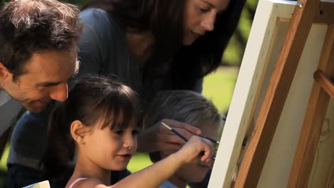 Childs-painting-a-canvas-with-their-parents-