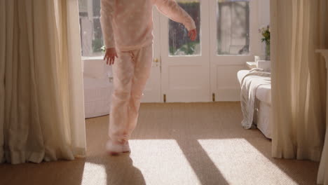 beautiful teenage ballerina girl practicing ballet dancing in bedroom rehearsing dance on weekend morning wearing pajamas at sunrise