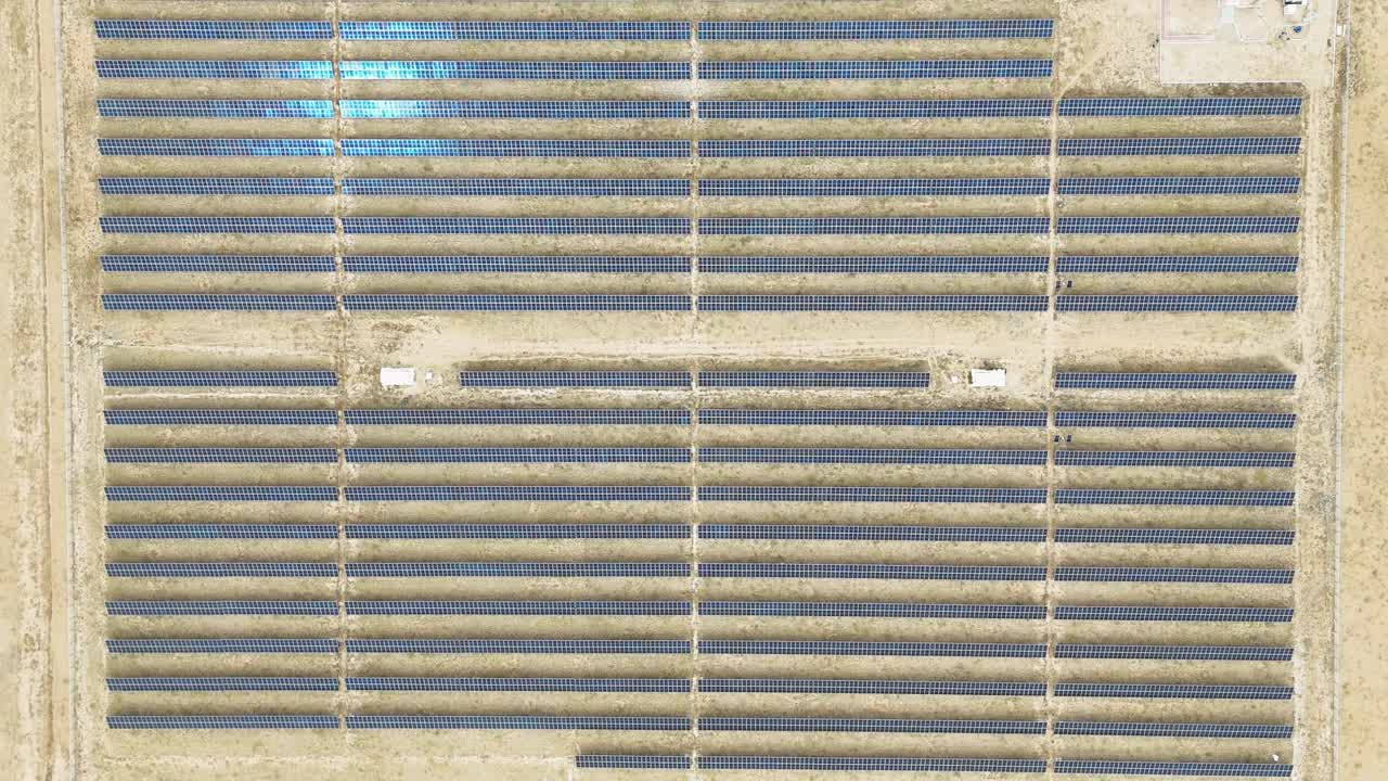 A drone captures a top-down view of hundreds of solar panels in Uliastai desert, Mongolia. This perspective highlights the vast scale of the renewable energy plant in a remote setting.