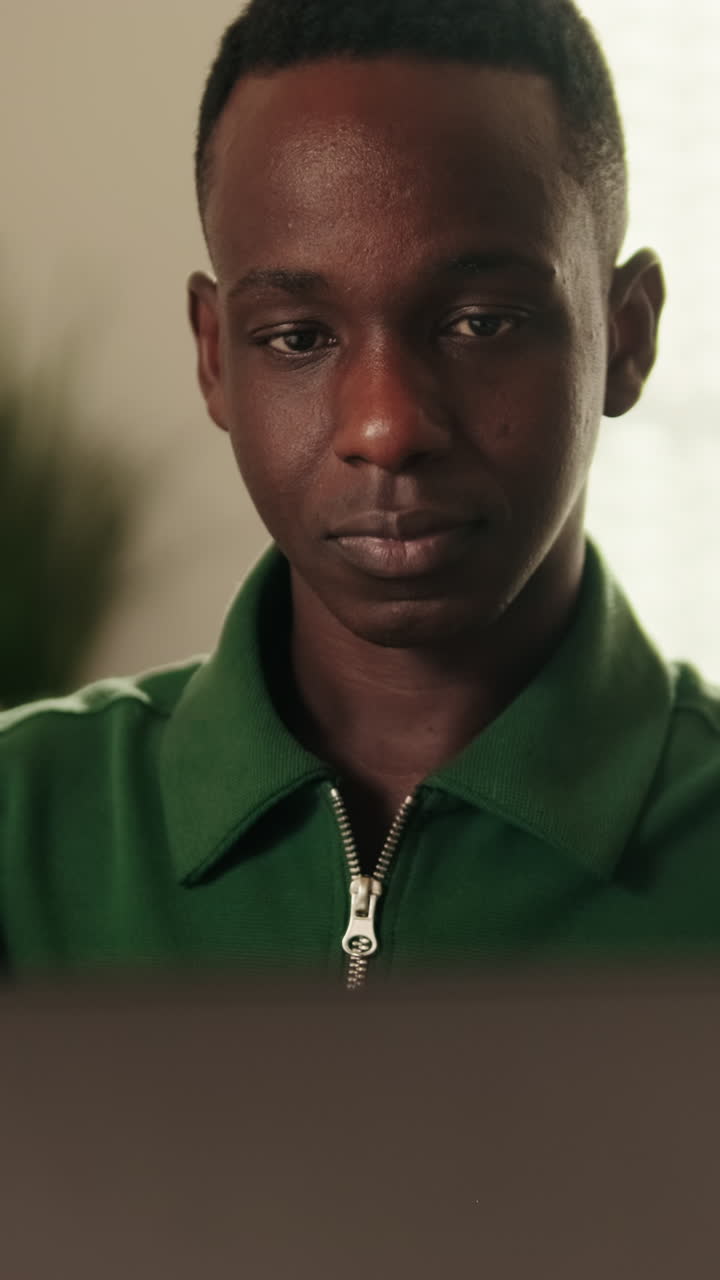 Young Black Man Looking at Laptop and Smiling