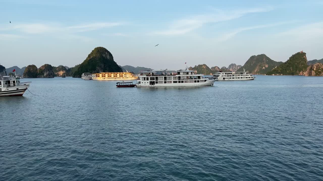 bahía de halong, vietnam, moviéndose hacia botes chatarra anclados en aguas tranquilas