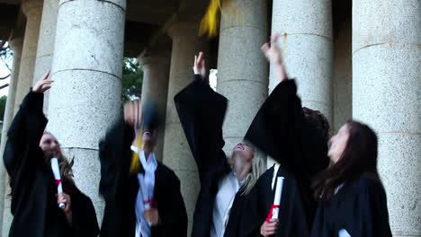 estudiantes graduados lanzando tablas de mortero en el aire