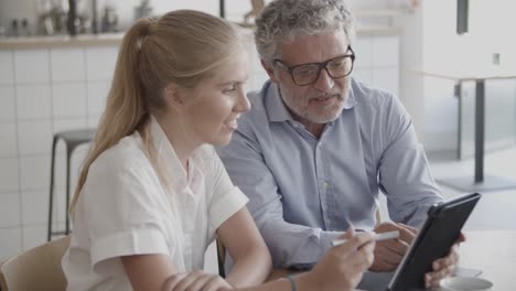 young blonde secretary listening bearded ceo and giving pen