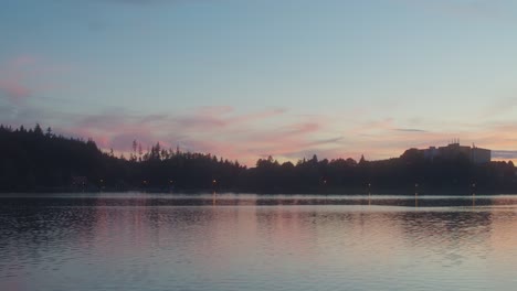wide shot showing blue hour after sunset at horizon. tree reflection in water surface. beautiful nature shot.
