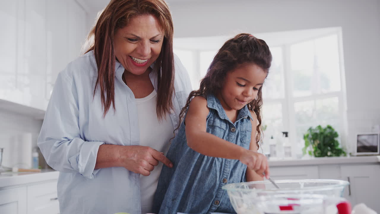 joven haciendo pasteles con su madre y abuela llenando formularios de pasteles con mezcla, de cerca, de mano