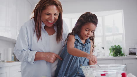 Junges-Mädchen-Backt-Kuchen-Mit-Ihrer-Mutter-Und-Großmutter-Und-Füllt-Kuchenformen-Mit-Mischung,-Nahaufnahme,-Handgehalten