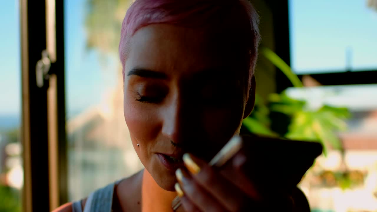 mujer de cabello rosa hablando por teléfono móvil 4k