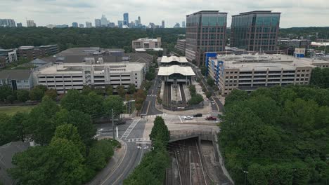 Aerial-approaching-shot-of-Lindbergh-Marta-Station-wit-Atlanta-Downtown-in-background