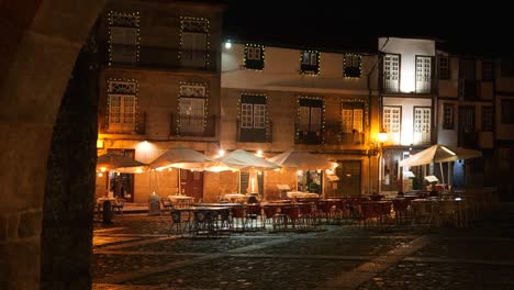 rainy christmas night at largo da oliveira, guimarães ,historic church and festive lights