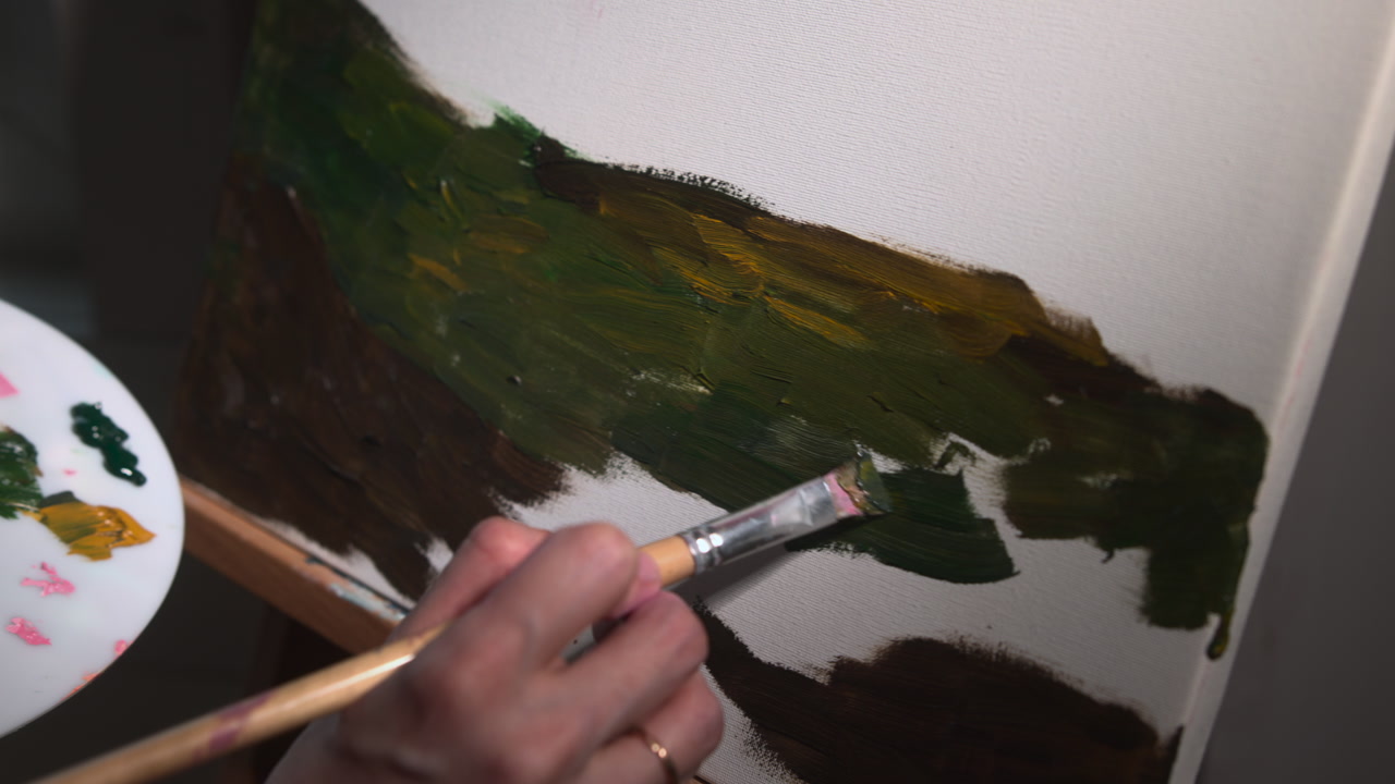 Caucasian Landscape Painter Blocking Dark Foreground Hill With Broad Brush Closeup, Sweeping Green Passages . Media