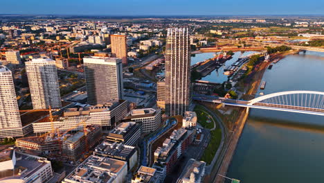 modern neighborhood with a construction cite at the waterfront of the danube. vast cityscape of bratislava, slovakia at sunset