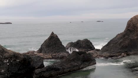 Una-Ola-Que-Salpica-Entre-Dos-Pilas-De-Mar-En-La-Costa-Del-Pacífico