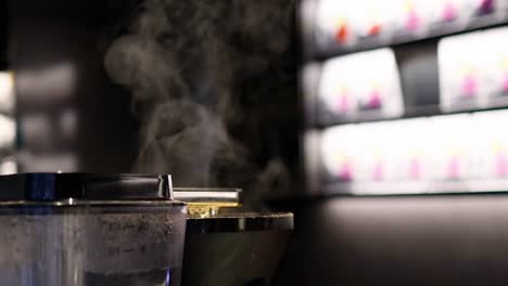 close-up of steam billowing from a coffee maker in a cafe setting, highlighting the brewing process.