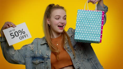 una adolescente alegre mostrando bolsas de compras y hasta un 50 por ciento de descuento en las inscripciones del cartel, black friday