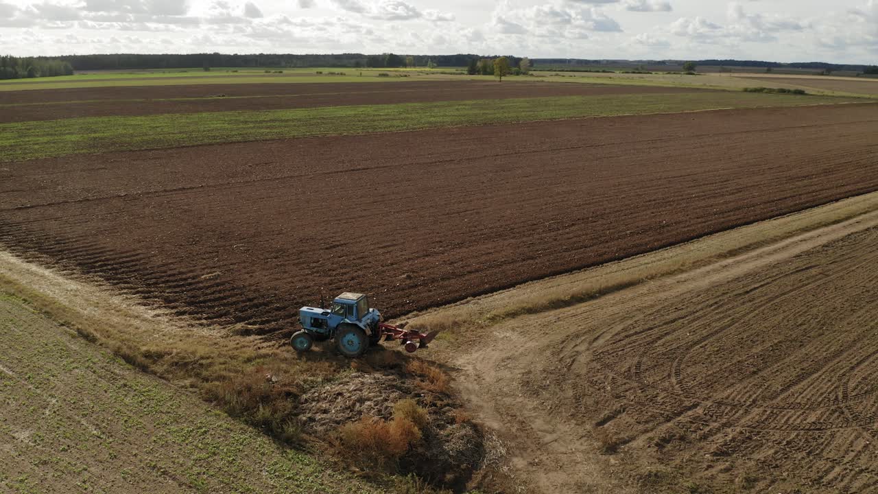 vista superior de un campo agrícola y un tractor en letonia - tiro rodante