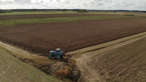 top view of agricultural field and tractor in latvia - rolling shot