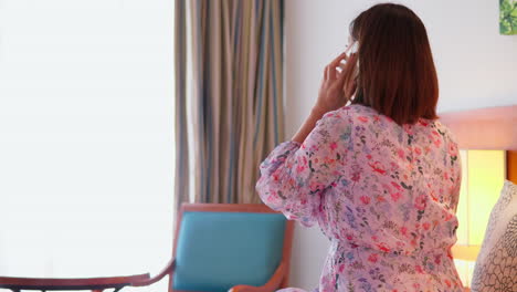 asian woman using smartphone at bedside