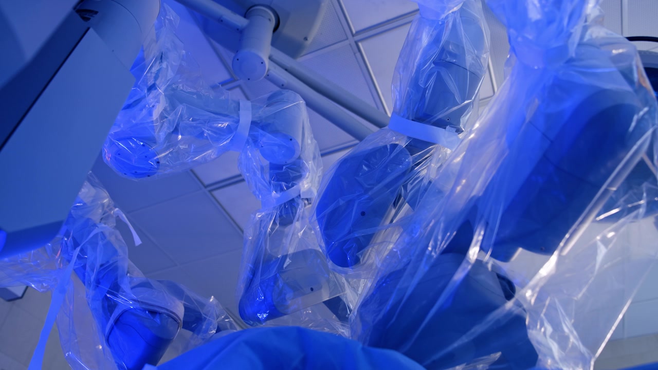 Robotic surgeon manipulator arms covered in plastic. Low angle view on Da Vinci Surgical system in modern surgery room.