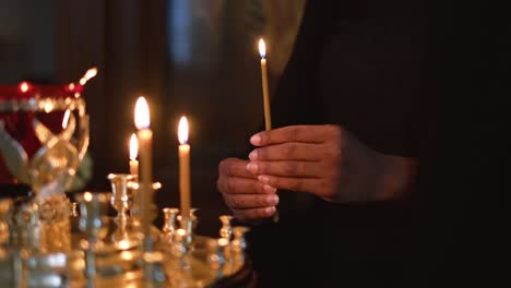 Woman-is-holding-a-lighted-candle,-religious-and-spiritual-concept