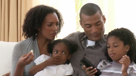 Close-up-of-AfroAmerican-parents-and-children-watching-television-