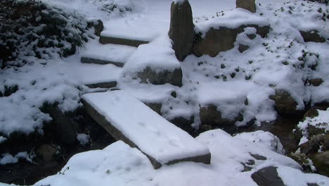 Zoom-out-Lento-En-La-Pasarela-Cubierta-De-Nieve-Y-El-Jardín-Japonés