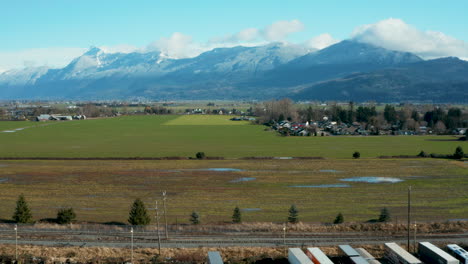 Scenic-aerial-view-of-farm-land-with-mountains-in-the-distance
