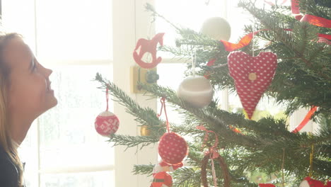 Niña-Colgando-Adornos-En-El-árbol-De-Navidad