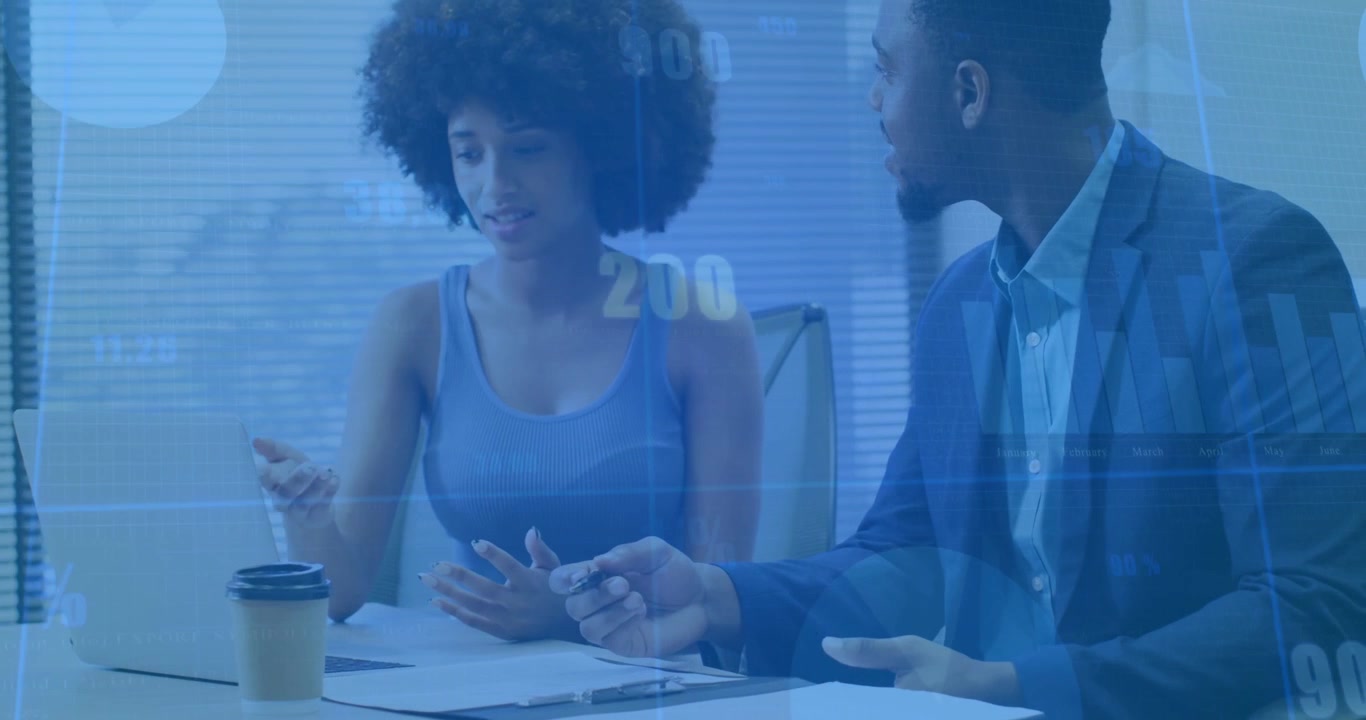 Woman reaching laptop and pointing, man taking notes, blue data overlay highlighting finance charts