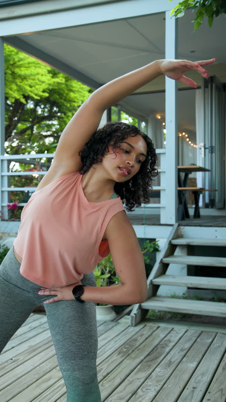 Vertical video: Exercising outdoors, woman wearing smartwatch during refreshing workout session