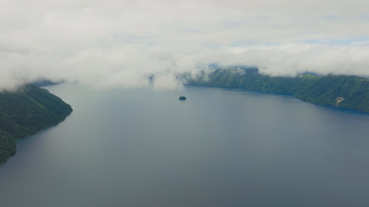 Aerial slow motion fly at Lake Mashu's Surrounding Forested Landscape, Japan Hokkaido famous volcanic crater