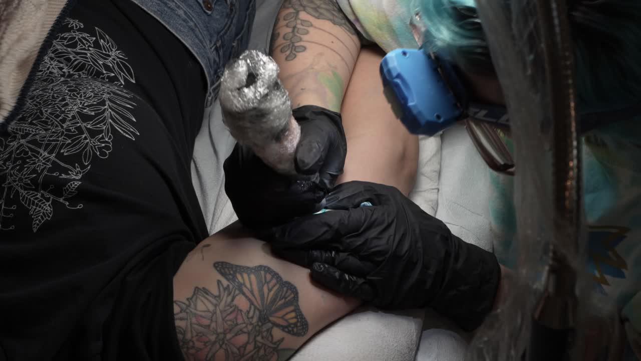 Tattoo Artist Applying New Tattoo on Woman's Arm