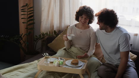 couple enjoying a romantic easter breakfast in bed