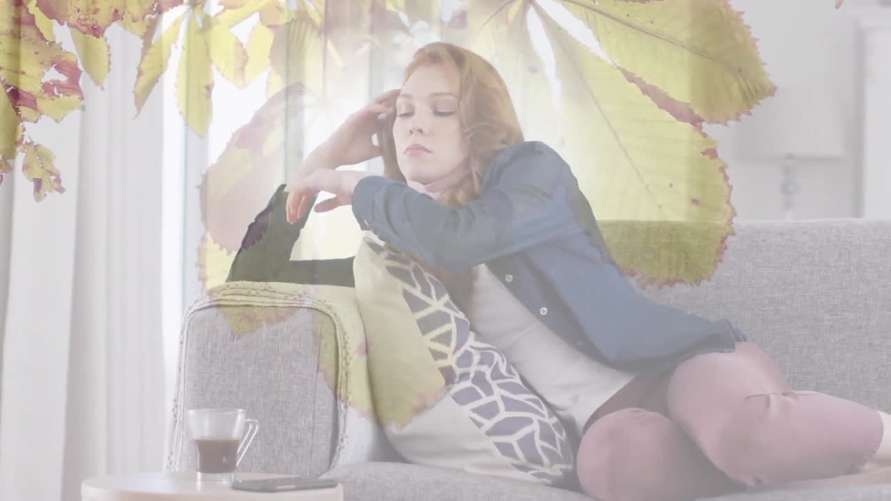 소파에 앉아있는 백인 여성 위에 가을 잎의 애니메이션