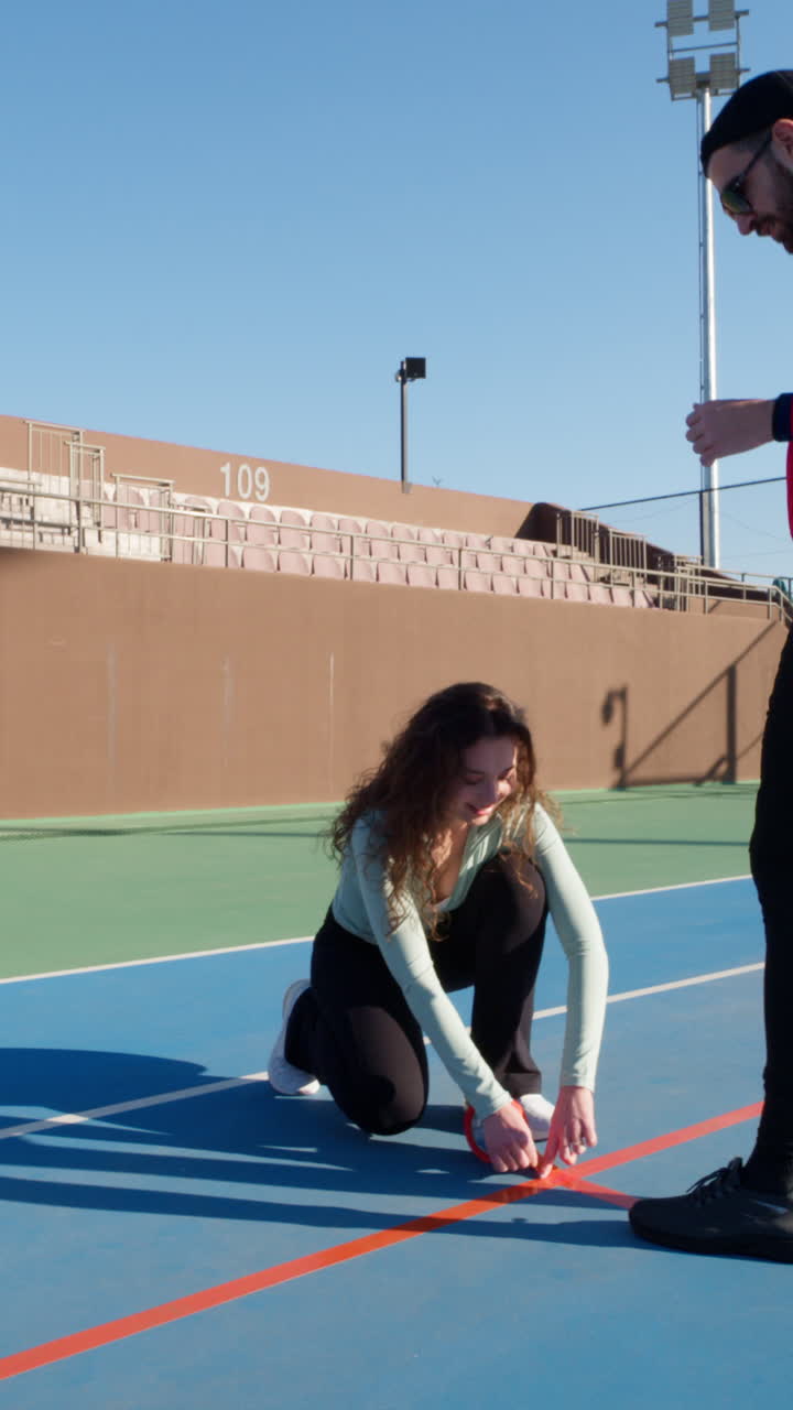 Group of friends converting tennis court into a pickleball court on a sunny day