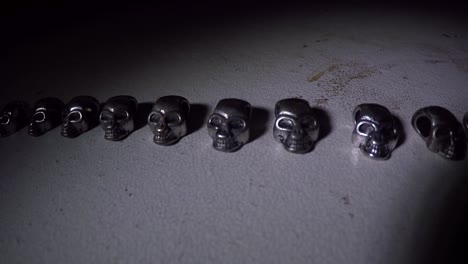 mini silver skulls on a table in the dark