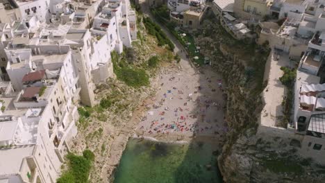 Imágenes-Aéreas-De-La-Playa-De-Lama-Monachile-En-Polignona-A-Mare,-Italia-Con-Bañistas-Relajándose