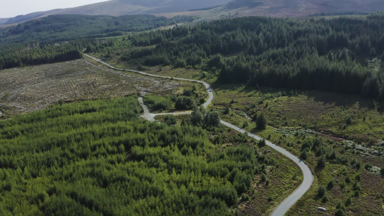 vista aérea de los coches que circulan por una larga y sinuosa carretera de montaña en las montañas de wicklow en un día soleado-4