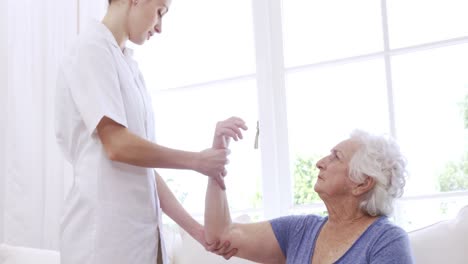 Enfermera-Revisando-El-Brazo-De-La-Mujer-Mayor