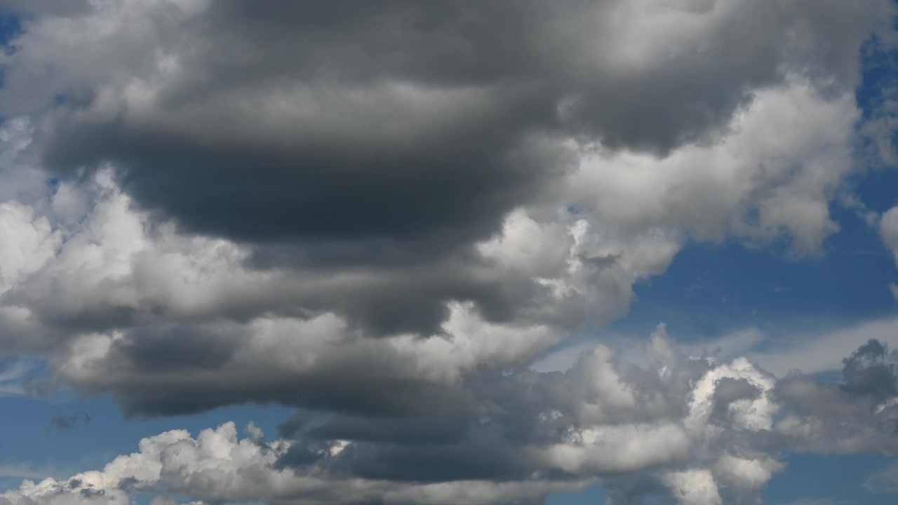 Dramatic cumulus clouds fill the sky, suggesting an approaching weather change or storm.