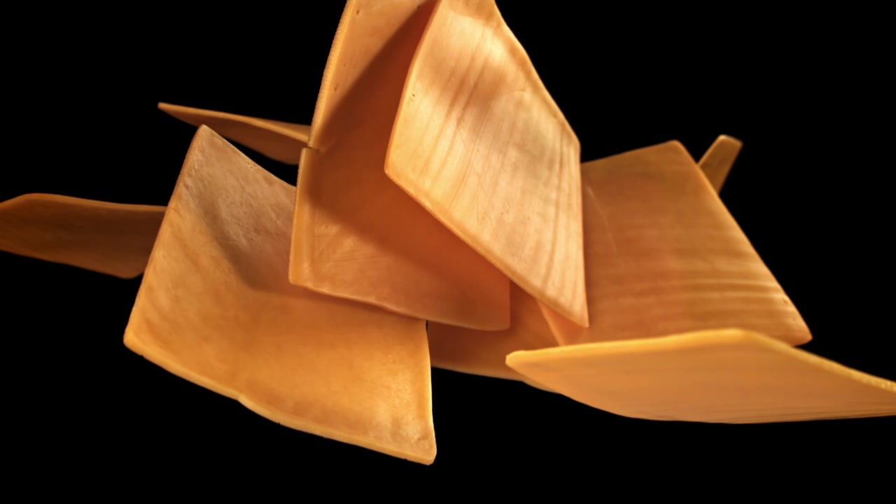 Slow Motion of Yellow Cheese Slices Falling and Piling Up