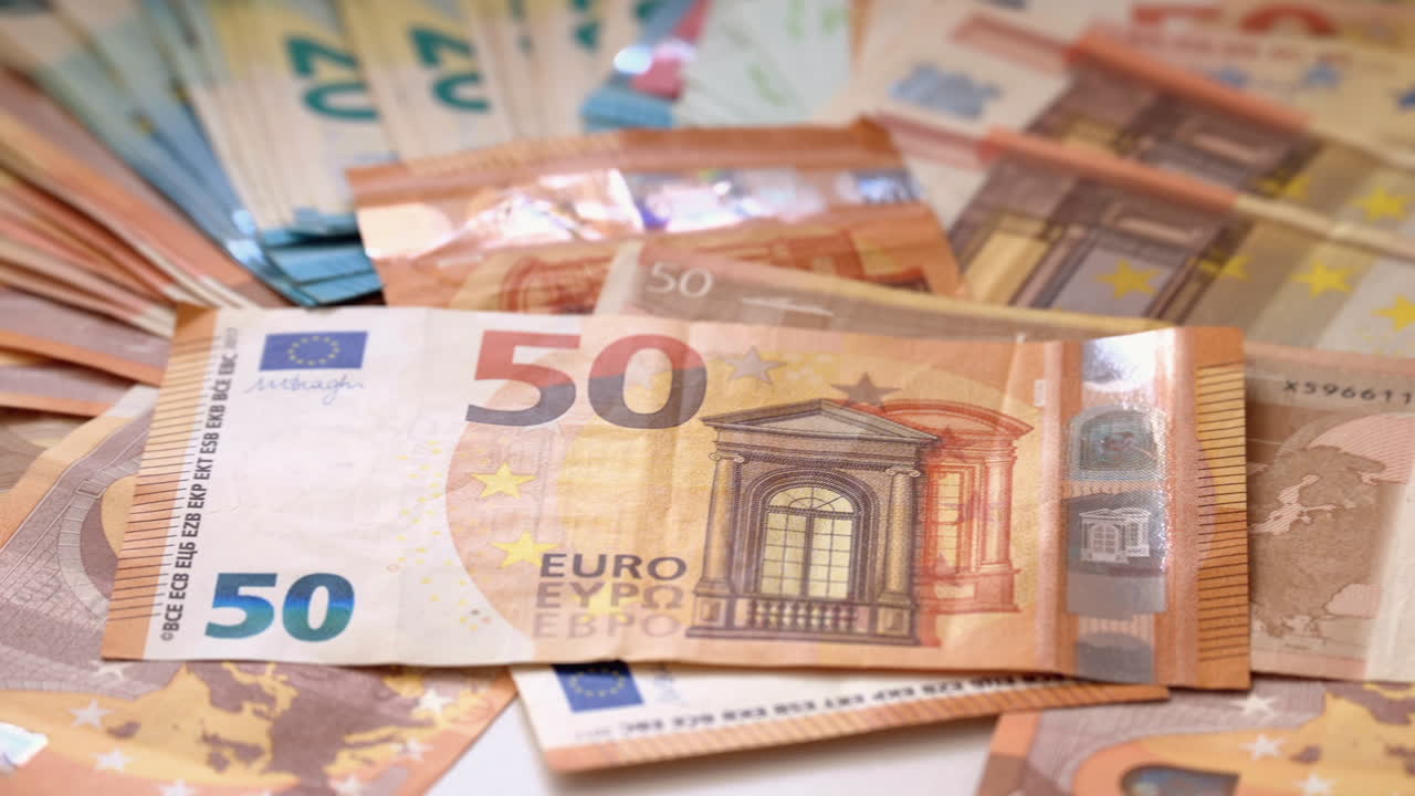 Multiple 20, 50 and 100 euro bills on a surface