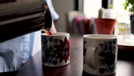 Zeitlupenaufnahmen-Einer-Frau,-Die-Kaffee-In-Eine-Tasse-Gießt