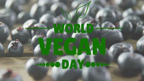 animation of world vegan day text over fresh blueberries